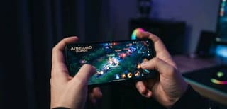 Budget smartphone displaying a mobile game on a dark background