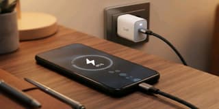 Smartphone charging rapidly with a GaN fast charger and power cable on a desk