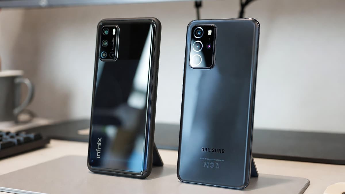 A mid-range Android phone placed beside a flagship smartphone on a desk