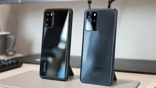 A mid-range Android phone placed beside a flagship smartphone on a desk