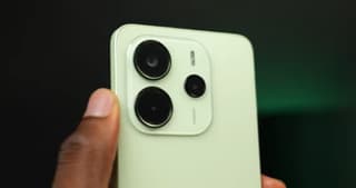 Redmi Note 14 held in hand against a blurred background, looking sleek but hiding its limitations