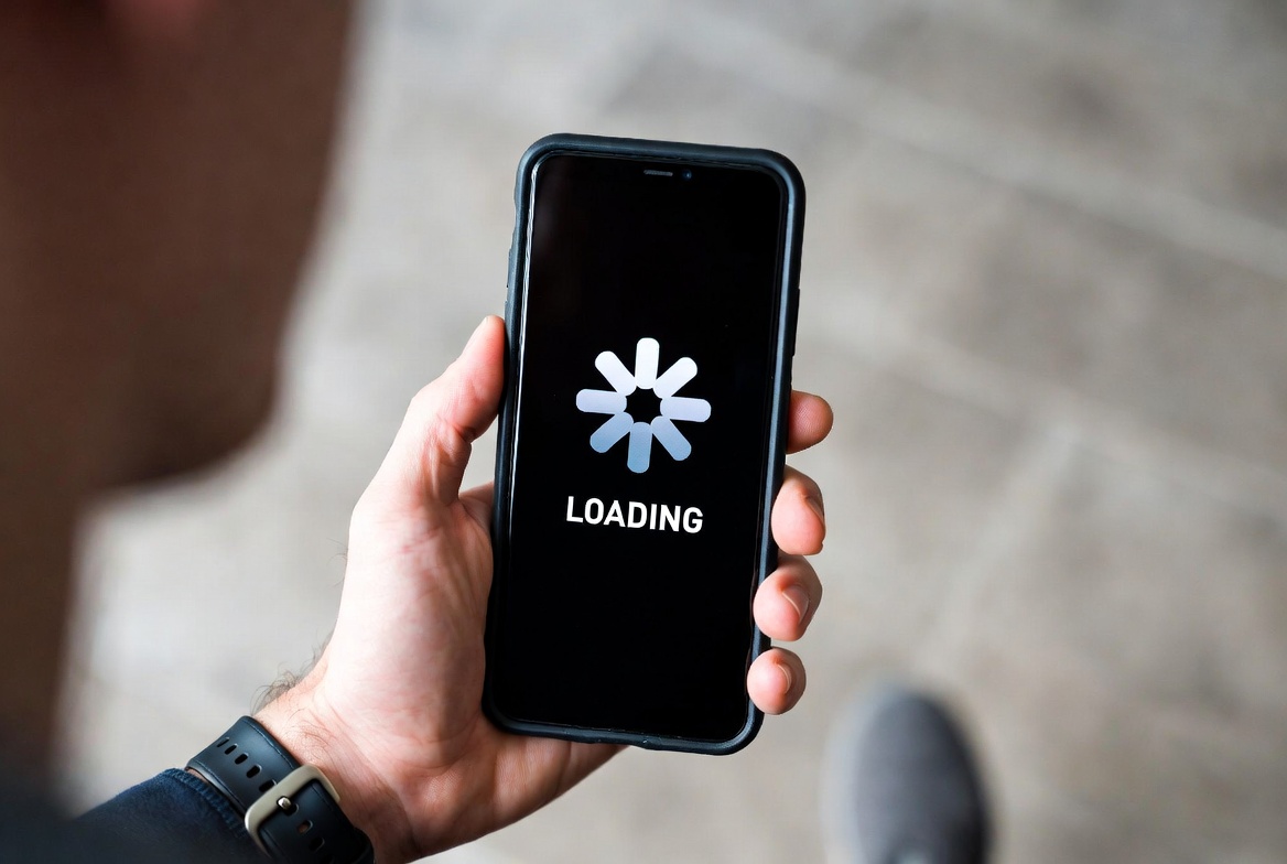 Person looking frustrated at a slow loading screen on a budget phone