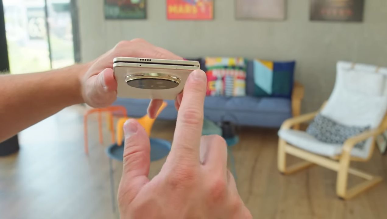 Honor Magic V5 shown half-folded to show hinge thinness