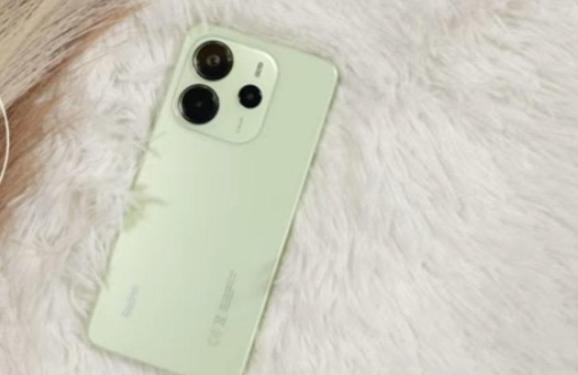 Redmi Note 14 lying on a desk showing its back panel and camera module, looking deceptively premium for its price