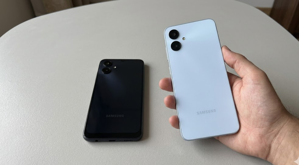 Samsung Galaxy A06 on a light background with hands using it