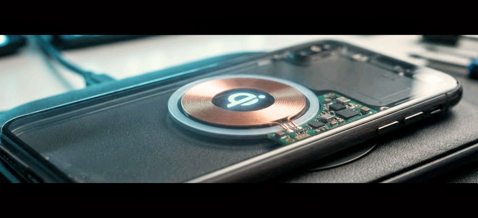 Close-up of a phone charging coil symbol on the back of a smartphone