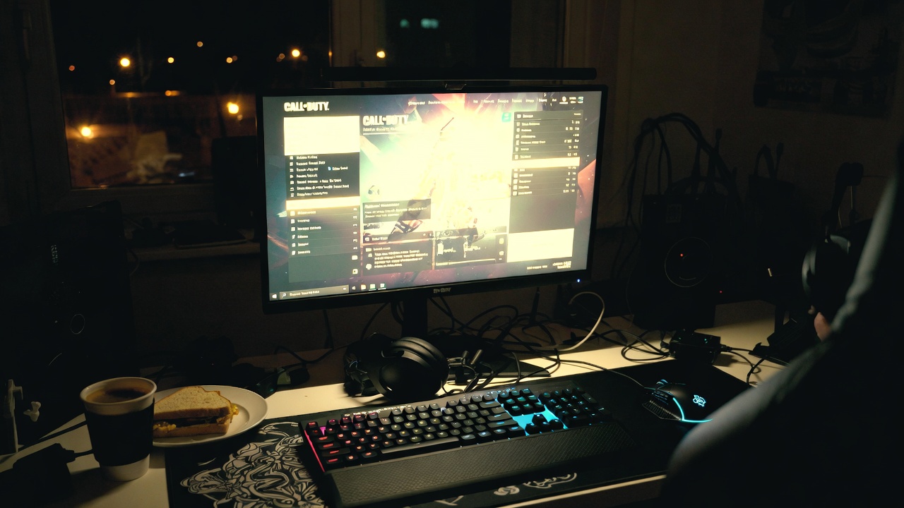 Late night gaming desk with Call of Duty on screen