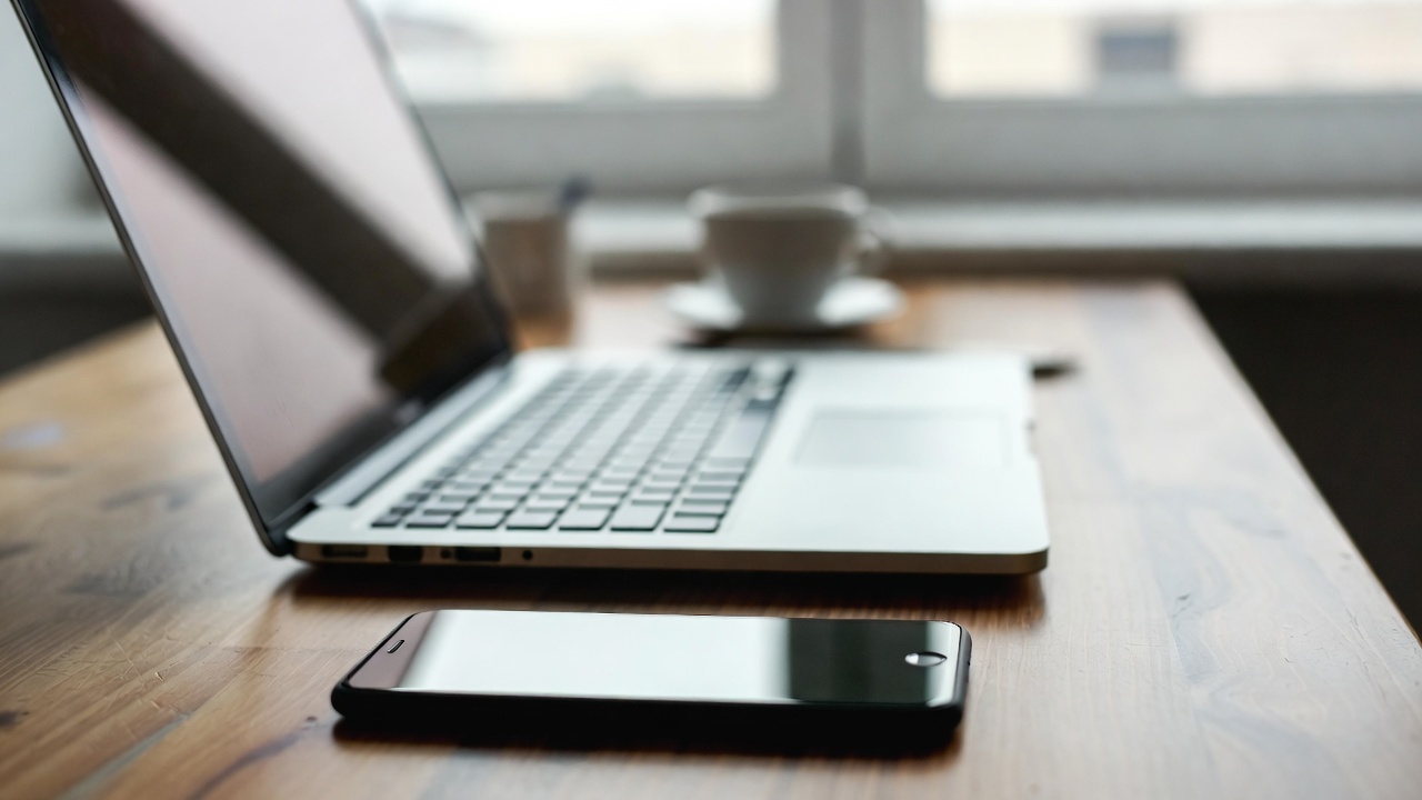 Mobile device beside laptop computer